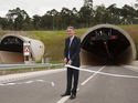 UK government transport secretary Philip Hammond cuts the ceremonial ribbon to open at least half of the country's longest land-locked road tunnel